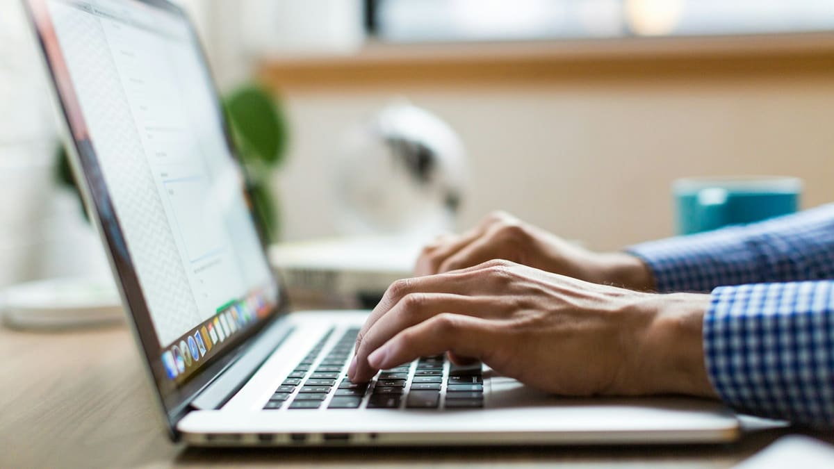 Hands typing on a laptop keyboard