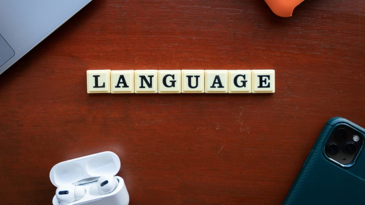 The word language spelled with letter tiles on a table